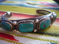 Native American Indian sterling silver jewelry, and Navajo sterling silver jewelry, a beautiful Navajo bracelet of sterling silver with four wonderful turquoise stones, with twisted wire bezzles and bump-outs, Arizona or New Mexico, c. 1960's. A closeup photo of some turrquoise stones.