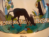 Mexican vintage pottery and ceramics, a lovely plate with a cream-colored background glaze and a wonderful and very serene scene of a burro munching grass under graceful trees and foliage, Tlaquepaque, Jalisco, c. 1930's.  Closeup photo of the burro.