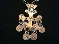South American antique silver jewelry, a very beautful cross on a hand-made sterling chain, from the Malpuchi of Southern Chile, c. 1880-90's. The Malpuchi cross features a skull near the top, and has circular siver dangles hanging from the arms and bottom. Closeup photo of the silver cross.