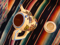 Mexican vintage pottery and ceramics, a beautiful coffee pot with a cream-colored background glaze and exquisite floral decorations, Tlaquepaque, Jalisco, c. 1940's. Photo shot from above with lid removed, showing the top and inside of the pot and lid.