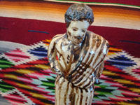 Mexican vintage folk-art, and Mexican vintage pottery and ceramics, a wonderful pottery statue of a Mexican caballero with a sarape gracefully draped over his shoulder and wearing a wonderful striped suit, attributed to the great folk-artist, Senora Pena of Tzintzuntzan, Michoacan, c. 1960's. Closeup photo of the caballero's face.