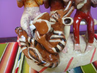 Mexican vintage folk art, a pottery sculpture of three men with a playful devil in front (possibly representing the Trinity of Father, Son, and Holy Spirit), Ocumicho, Michoacan, c. 1950's. Closeup photo of the playful devil near the front of the piece.