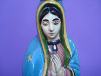 Mexican vintage folk art, a pottery bottle representing Our Lady of Guadalupe, Tonala or San Pedro Tlaquepaque, c. 1930's. Closeup photo of the Virgen's face.