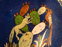 Mexican vintage pottery and ceramics, and Mexican vintage folk art, a pottery plate from Tlaquepaque, Jalisco, with a wonderful scene of a fox and beautiful bird (a quetzal), on a dark blue slip, c. 1930-40. A closeup photo of the center of the plate.