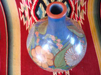 Mexican vintage pottery and ceramics, a wonderful burnished jar from Tonala, c. 1930's. The burnished jar is decorated with beautiful flowers, and has a wonderful blue background. Photo showing a view from above the jar.