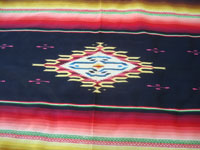 Mexican vintage textiles, and Mexican vintage Saltillo serapes (sarapes) and huipiles, a wonderful and very colorful Saltillo-style serape with a beautiful center medallion and embroidery between bands of color, c. 1940's.  Closeup photo of the center medallion of the serape.