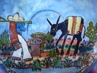Mexican vintage pottery and ceramics, a beautiful pottery plate with a wonderful blue background glaze, resembling a watercolor wash, and magnificent artwork, attributed to the great Balbino Lucano, Tonala or San Pedro Tlaquepaque, Jalisco, c. 1930's. Closeup photo of the man and his burro.