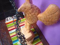 Mexican vintage folk art, a beautiful eagle carved of wood with a hand-twisted wire snake in its mouth and perched on a beaver cactus, the emblem of the nation of Mexico, Oaxaca, 1950's. A side view of the eagle.
