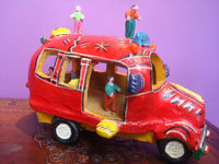 Mexican vintage folk art, a wonderful pottery red bus with eight delightful passengers, including the driver, happily traveling to the beach city of Acapulco, attributed to the great Candelario Medrano, Santa Cruz de las Huertas, Jalisco, c. 1950's. A side-view of the bus.