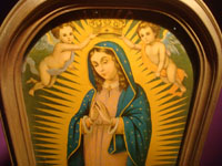 Mexican vintage devotional art, a framed print of Our Lady of Guadalupe crowned by two lovely angels, c. 1940's. Closeup photo of Our Lady's face.