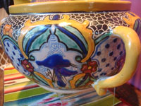 Mexican pottery and ceramics, a beautiful talavera pottery bowl with incredible glazing and artwork, Puebla, c. 1940's. A closeup photo of the artwork on one side of the talavera bowl.