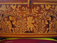 Mexican vintage folk art, and Mexican vintage woodcarvings and masks, a fabulous wooden escritorio (portable writing desk) with very fine marquetry inlay work, Oaxaca, c. 19th century. Closeup photo of the marquetry on the front cover of the desk, featuring human figures and floral designs.