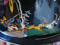 Mexican vintage pottery and ceramics, a beautiful blackware charger with a wonderful scene of a hunter aiming his rifle at a fierce eagle, as gazelles wander by, Tonala or San Pedro Tlaquepaque, c. 1940's. Closeup photo of the bottom of the charger showing the hunter and the gazelles.
