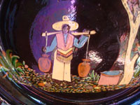 Mexican vintage pottery and ceramics a beautiful blackware plate of a scene of a paisano coming from the well with full jarros (jars) of water. Closeup photo of the front of the platee.