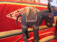 Mexican vintage folk-art and Mexican vintage wood-carving, a wonderful pair of wood-carved and hand-painted burros, complete with painted saddles and horse-hair (or burro-hair) tails, c. 1930.  A closeup photo of the side of one of the burros.
