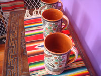 Mexican vintage pottery and ceramics, a set of three pottery petatillo (background of fine cross-hatching resembling a straw mat or petate, in Spanish) chocolate cups, with fabulous artwork, signed by the great Jose Bernabe, Tonala or San Pedro Tlaquepaque, c. 1930's. A side view of the three cups showing the handles.