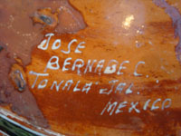Mexican vintage pottery and folk art, a lovely petatillo casserole with lid, Tonala, Jalisco, c. 1950-60, by famed artist Jose Bernabe. The casserole features wonderful and very intricate floral and zoomorphic figures. Photo of the bottom of the casserole with Barnabe's signature.