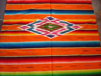 Mexican vintage textiles, and Mexican vintage Saltillo sarapes and huipiles, a beautiful Saltillo sarape (serape) with a lovely orange background and a stunning center medallion of silk and wool, c. 1930's.  Closeup photo of the center medallion of the serape.
