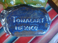 Mexican vintage folk art, and Mexican vintage pottery and ceramics, a lovely glazed statue of a Mexican gentleman relaxing and peering over the edge of his wonderful serape (sarape), Tonala or San Pedro Tlaquepaque, c. 1940.  Photo of the bottom of the piece, stamped with Tonala Mexico."