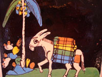 Mexican vintage pottery and folk art, a blackware tile with a scene of a very endearing and whimsical burro amidst plants and foliage, Tlaquepaque, Jalisco, c. 1930's. Closeup of the burro and his load walking through the Mexican countryside.
