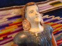 Mexican vintage pottery and ceramics and Mexican vintage folk-art, a wonderful bank in the form of a lovely Mexican woman, c. 1940's. The woman's face is very serene and beautiful, and the doll-bank has great patina. Closeup of the woman's face.