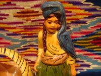 Mexican vintage pottery and ceramics and Mexican vintage folk-art, a lovely pottery figurine depicting a lovely woman with a basketl, Tonala or Tlaquepaque, Jalisco, c. 1930's. The woman's face is incredibly beautiful. Closeup of the maiden's face.