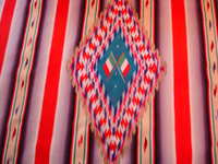Mexican vintage textiles, and Mexican vintage Saltillo serapes (sarapes), a stunning Saltillo serape with color-hues of soft-red, lilac, purple, green, and soft-yellow, c. 1910-20.  Closeup photo of the center medallion of the serape, with wonderful Mexican flags.
