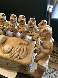 Mexican vintage folk art, an Ocumicho pottery sculpture piece depicting the Last Supper, with a Christ figure at one end of the table, and thirteen (13?) apostles at a table preparing to eat a meal with fish and bread, Ocumicho, Michoacan, c. 1950's. Closeup photo of one end showing some of the apostles.