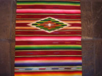 Mexican vintage textiles and Saltillo-style serapes (sarapes), a very fine Saltillo serape runner with beautiful color combinations and a wonderful silk center medallion, c. 1930's. Closeup photo of the center silk medallion.