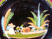 Mexican vintage pottery, a blackware plate from Tlaquepaque, Jalisco, c. 1930's. It features a very beautiful rural scene and a wonderful floral border. Closeup photo of central design of plate.