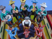 Mexican vintage folk art, a wonderful Ocumicho pottery scene of a lively rodeo, complete with a bull-rider, musicians, and fans, Ocumicho, Michoacan, c. 1980's. Closeup photo of the rider and the band.