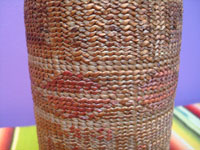 Native American Indian antique baskets, a Tlingit hand-blown glass bottle with wonderful weaving around it, c. 1900. Closeup photo of part of the bottle showing the tight weave and beautiful embroidered decorations.