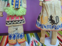 Mexican vintage folk art, a pair of carved wooden figures in traditional Huichol costumes, Nayarit, c. 1950's. Closeup photo showing the embroidery on the clothes.