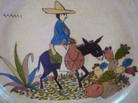 Mexican vintage pottery and ceramics, a beautiful pottery charger with a cream-colored background and very fine artwork, Tonala or San Pedro Tlaquepaque, c. 1930's. Closeup photo of the rider on his burro.