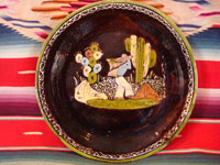 Mexican vintage pottery and ceramics, a blackware plate with wonderful artwork from Tlaquepaque, Jalisco, c. 1930-40's. The plate has a beautiful border and a scene of a campesino carrying his heavy load amidst plants and cacti.  Main photo.