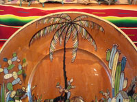 Mexican vintage pottery and ceramics, an incredibly large charger with an intricately painted scene of a campesino returning home with his burro, Tlaquepaque, Jalisco, c. 1920's. Photo of the top of the palm tree at the top of the charger.