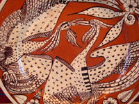 Mexican vintage pottery and ceramics, a lovely charger with a terra-cotta background and two fantasia-style birds, Tlaquepaque, Jalisco, c. 1940's. Closeup photo of the artwork on the front of the charger, showing the graceful art-deco birds.