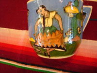 AE-1: Mexican vintage pottery and ceramics, a tea-cup and saucer with incredibly fine artwork, featuring a lovely Charra, dressed in her China Poblana costume, doing the famous dance, El Jarabe Tapatio, Tlaquepaque or Tonala, Jalisco, c. 1930. Closeup photo of the dancers on the sides of the cup.