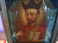 Mexican vintage devotional art, a retablo painted on tin depicting St. Ignatius of Loyola, founder of the Society of Jesus, Jesuits, c. 1930's.  Closeup photo of the retablo showing St. Ignatius.