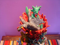 Mexican vintage folk art, and Mexican vintage pottery and ceramics, a beautiful pottery sculpture of a burning tower of devils delighted by the tasty fowl being roasted in a bowl on the top, Ocumicho, Michoacan, c. 1950. Photo of the top of the sculpture showing the fowl in the pan.