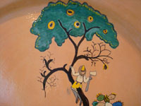Mexican vintage pottery and ceramics, a wonderful charger from Tlaquepaque, Jalisco, c. 1930's. Closeup photo showing one man climbing a tree with his ax in hand.