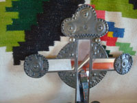 New Mexican tinwork art, and New Mexican folk art, a lovely candle-holder with wonderful stamping and mirrors, New Mexico, c. 1960's.  Closeup photo of the stamping near the top of the cross.