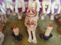 Mexican vintage folk art, a wonderful pottery piece depicting a gathering of souls or skeletons, perhaps Christ and the Apostles, or some rite of passage, Ocumicho, Michoacan, c. 1950's. Closeup photo of the central figure near the base.