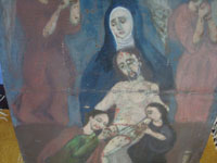 Mexican vintage devotional art, a retablo painted on tin showing Mother Mary, Mary Magdalen, an Apostle, and two angels taking the body of the Crucified Christ down from the Cross, c. 1940's. Closeup photo of Mother Mary holding the body of Christ.