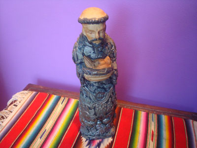 Mexican devotional art, a woodcarving of St. Francis of Assisi, beautifully carved and covered with beautiful milagros front and back, Michoacan, c. 1950's.