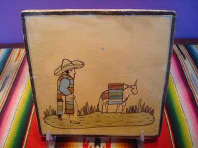 Mexican vintage pottery and ceramics, a wonderful pottery tile decorated with a scene of a campesino and his trusty burro returning from work, attributed to the great Balbino Lucano, Tonala or San Pedro Tlaquepaque, c. 1930's.