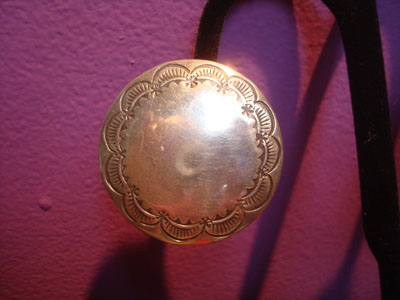 Native American Indian sterling silver jewelry, and Navajo sterling silver jewelry, a beautiful pair of earrings with fine stamping and silverwork, Navajo, Arizona or New Mexico, c. 1960. The earrings are very simple and elegant. Closeup photo of one earring.
